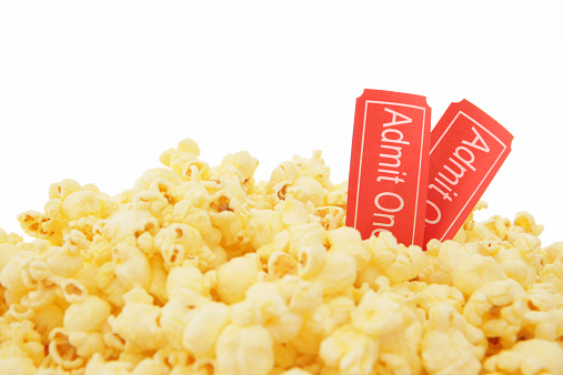movie tickets (with slight grain like texture) in popcorn on white background