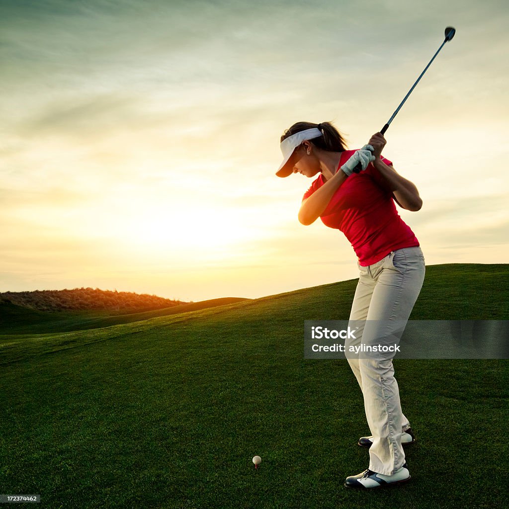 Kobieta Golfista Huśtać się o zachodzie słońca - Zbiór zdjęć royalty-free (Golf - Sport)