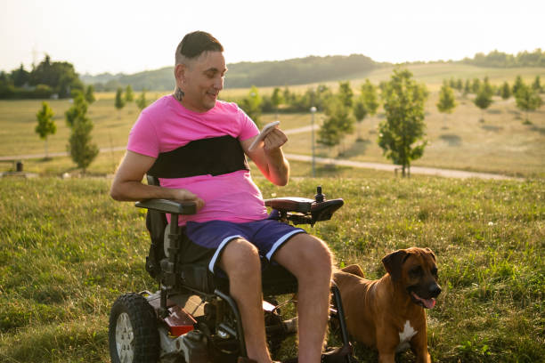 istock LGBT man with disability using a smart phone, while his dog lying near him in the park at sunset 1723745064