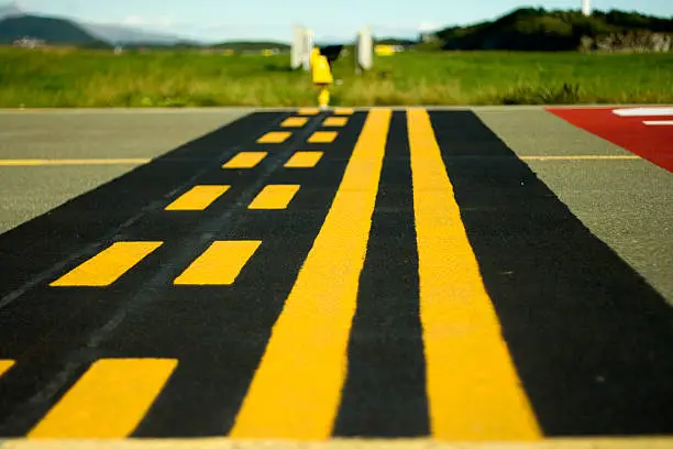 Image of runway holding point markings. No crossing of this line without clearance from the air traffic control.