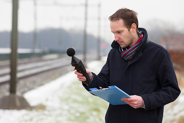 Sound pollution, man near railroad track "Noise pollution, noise measurements near railwayIf you want more images with noise pollution please click here." volume unit meter stock pictures, royalty-free photos & images
