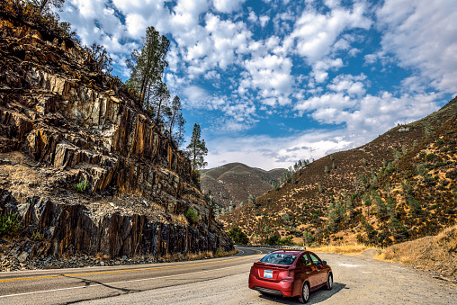 A car parked on the side of California State Route 140, en route from the city of Mariposa to Yosemite Valley in California, USA.