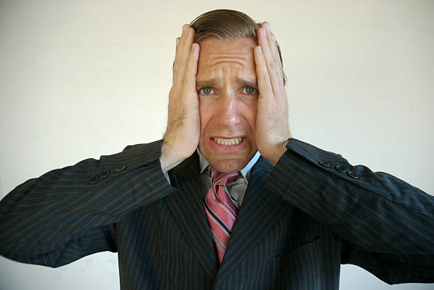 Regretful businessman holding head after a difficult mistake