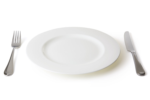 Place setting with plate, fork, and knife.  Isolated on white with soft shadow and clipping path.