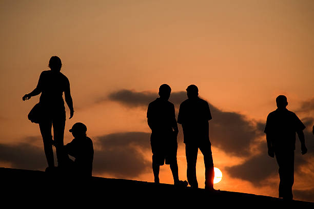 istock Silhouettes of people walking at sunset 172378295