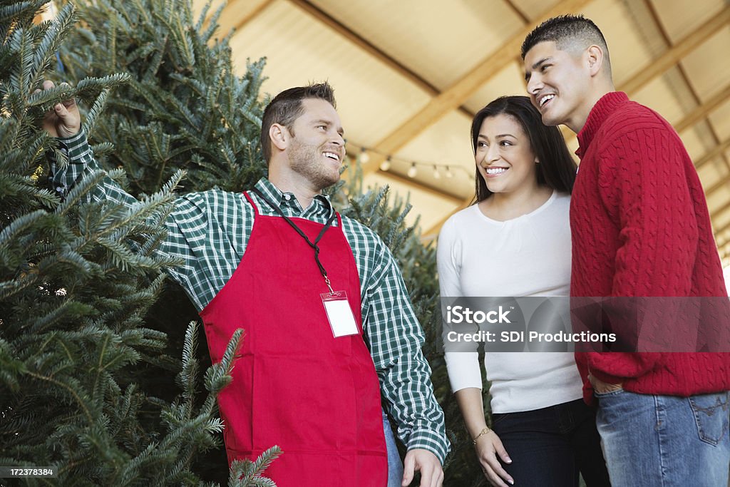 販売担当者によって購買クリスマスツリーのカップル - エプロンのロイヤリティフリーストックフォト