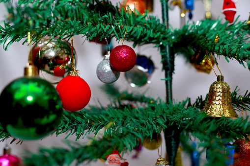 Decorative Christmas tree with hanging decoration on it. A Christmas tree is a decorated tree, usually an evergreen conifer, such as a spruce, pine or fir, or an artificial tree of similar appearance, associated with the celebration of Christmas.