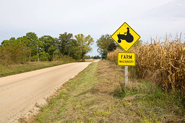 farm machinery sign a caution sign on a country road warning of farm machinery country road road corn crop farm stock pictures, royalty-free photos & images