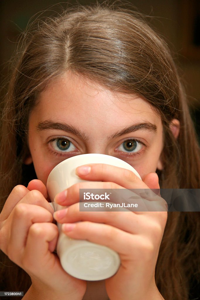 Young Woman's Eyes echar un vistazo entre detrás de una taza de café - Foto de stock de 14-15 años libre de derechos