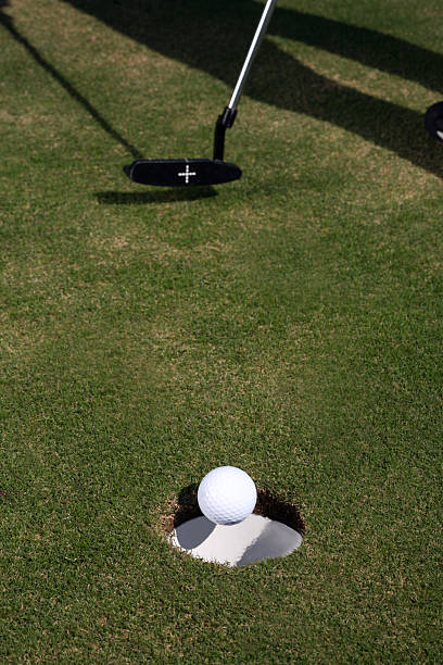 istock Golfer putts Golf Ball into hole with putter 172380087