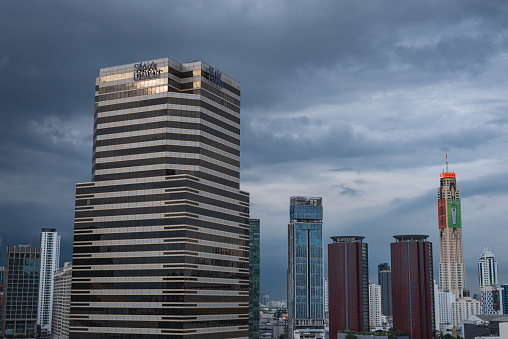 Bangkok, Thailand - September 16, 2023: Siam Piwat Tower and other skyscrapers of the downtown against the evening cloudy sky.