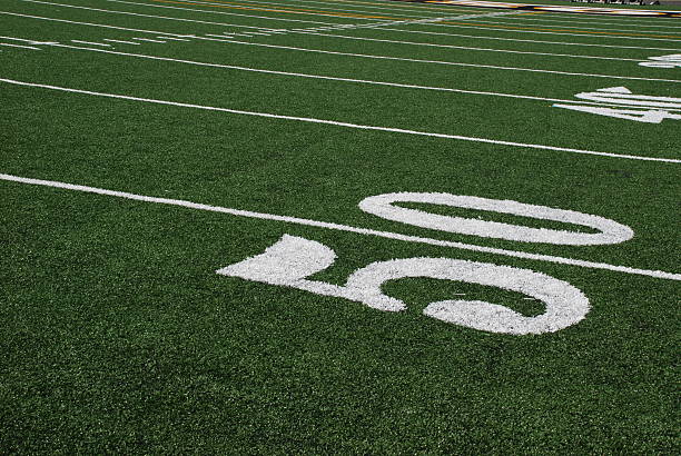 A football referee signals for play to start.