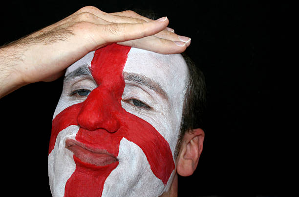 England Defeat A fan holds his head as England get defeated in a sporting event. Face painted with traditional St. georges day flag. wayne rooney stock pictures, royalty-free photos & images