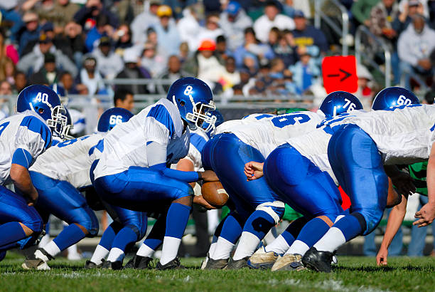 American High School Football. Beginning of a offensive play during a High School Football game. offensive line stock pictures, royalty-free photos & images