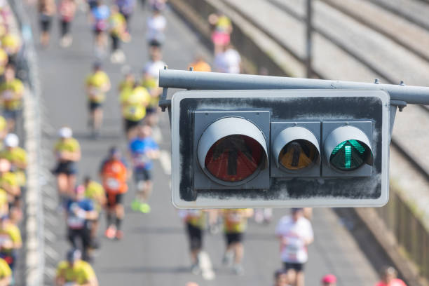 istock Traffic light in the foreground - people running a half marathon on the bridge 1723808257
