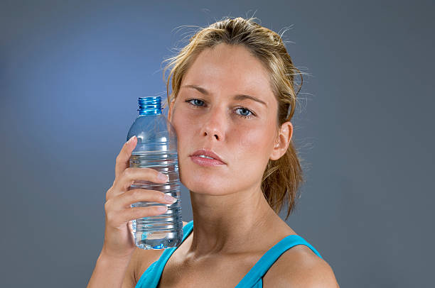 flasche wasser gegen wange - exercising sensuality water bottle relaxation exercise stock-fotos und bilder