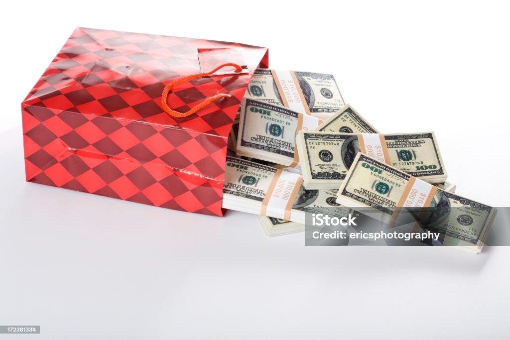 US dollars in gift bag Gift bag full of US dollars on white. A Helping Hand Stock Photo