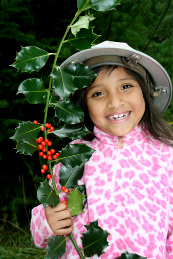 Young cute Latin girl with holiday holly.