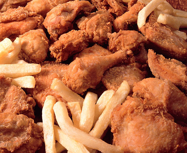 Pile of fried chicken and French fries stock photo