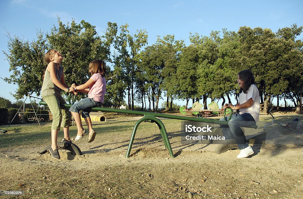 Seesaw Children playing at playground area.More at:Children groups (three or more) Lightbox: Seesaw Stock Photo