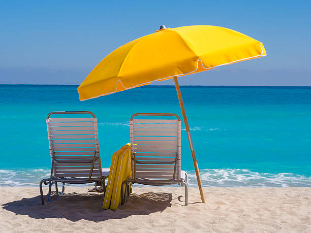Yellow Umbrella and deck chairs South Beach Miami "Yellow Beach umbrella and deck chairs on the beach on a clear day on South beach, Miami" beach umbrella stock pictures, royalty-free photos & images