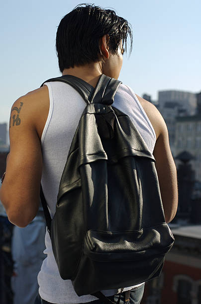азиатские студент с рюкзак стоя на улице в городской ландшафт-большой город - sophomore стоковые фото и изображения