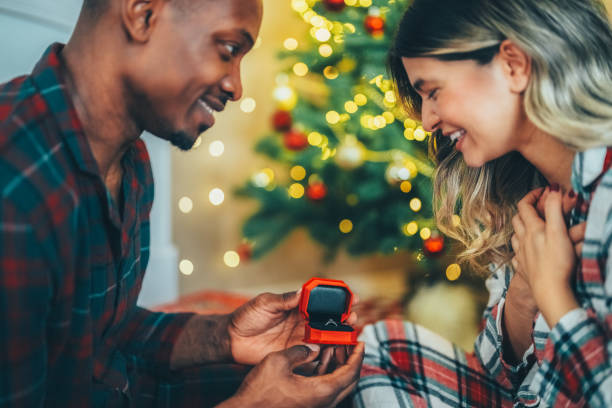 Young man proposing to his girlfriend on Christmas Eve