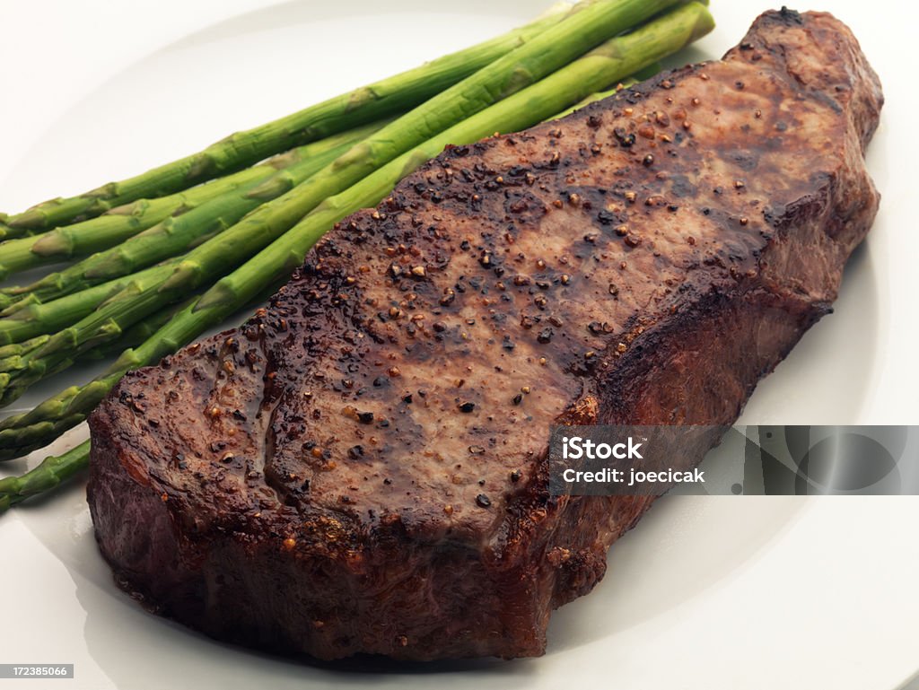 New York Strip Steak Broiled steak with Asparagus on white plate Asparagus Stock Photo