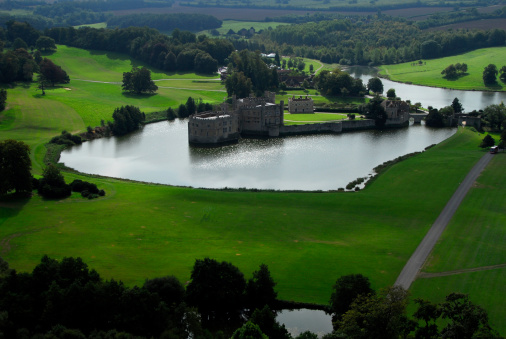 Medieval moated castle in the midst of vivid green landscape - from above.