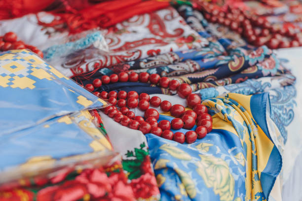 Folk ukrainian style scarves with floral patterns. Traditional Ukrainian ethnic style jewelry made with ceramic beads. Exclusive handmade necklaces at souvenir stall or street Sunday market. Selective focus bufandas de estilo ucraniano con motivos florales. joyería tradicional de estilo étnico ucraniano hecha con cuentas de cerámica. collares exclusivos hechos a mano en el puesto de souvenirs o en el mercadillo de los domingos. enfoque selectivo