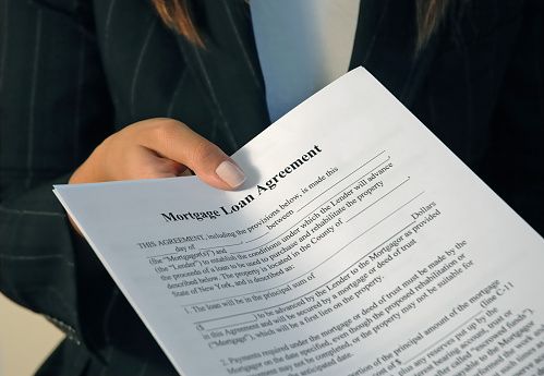 Business concept. Serious businesswoman with chained hands holding contract