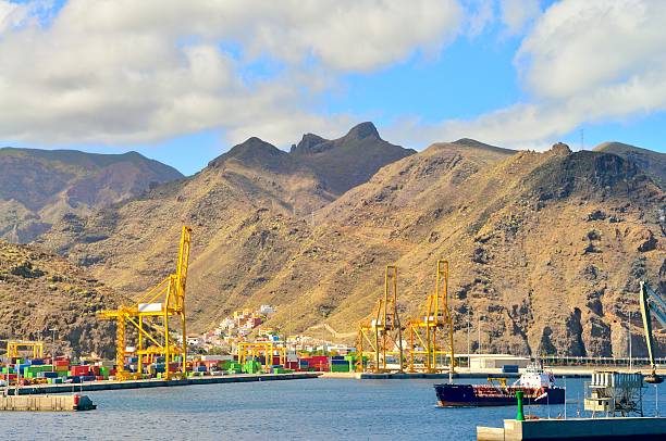 The primary container port in Santa Cruz de Tenerife with the requisite harbor cranes and shipping containers. An Oil Tanker is steaming out of port and if you look carefully you can see the Bemaja cave on the mountainside on the right. This also appears to the the main fishing dock for Santa Cruz. The ship is the Spabunker Cuarenta, a refueling ship for other ships or sea going gas station