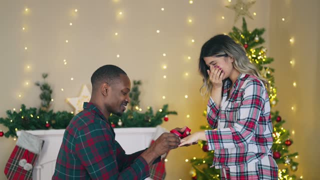 Young man proposing to his girlfriend on Christmas Eve