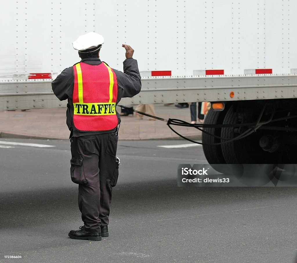 Traffic Cop with a Big Customer Traffic cop directs an 18-wheeler through a busy intersection. City Stock Photo