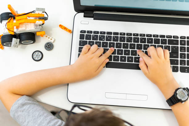 istock Unrecognizable smart young boy student in glasses builds and programs a robotic vehicle codes an electronic toy. 1723868015