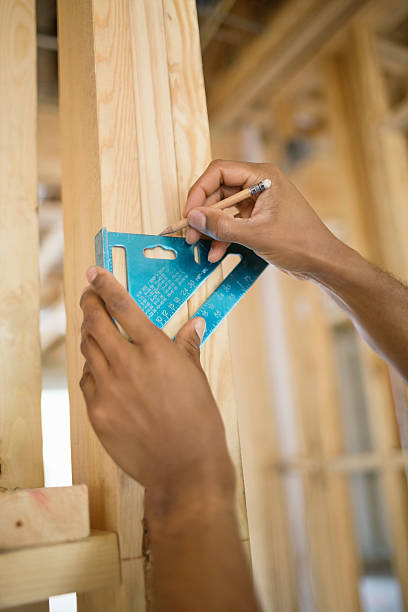 mão humana marcação de madeira com conjunto square no site - construction frame wood accuracy adult - fotografias e filmes do acervo