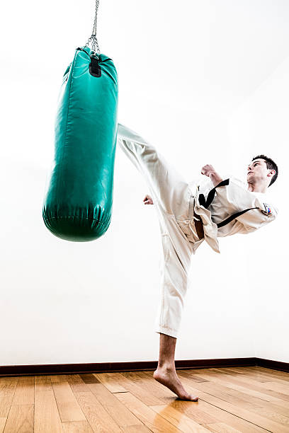 joven practicar artes marciales - kicking tae kwon do martial arts flying fotografías e imágenes de stock