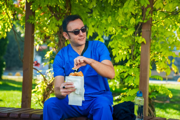 istock Man eating Turkish bagel at the park. 1723880349