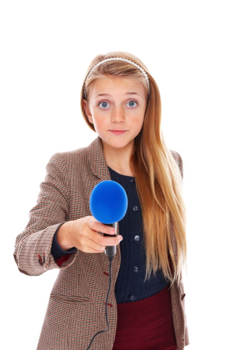 Beautiful little girl reporter with microphone taking your interview against white background
