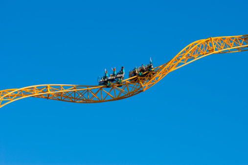 Yellow steel rollercoaster with unrecognisable passengers twisting with a blue sky backgroundPlease see some similar pictures from my portfolio: