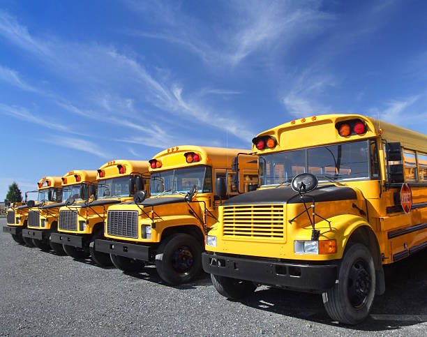 istock Row of yellow school buses against partly cloudy sky 172388705