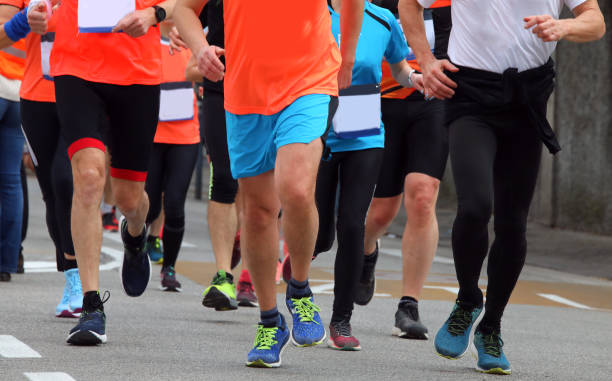 istock legs of runners running in group during foot race 1723893500