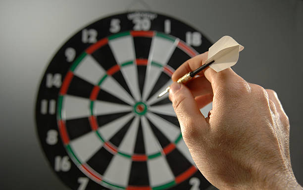 darts series shallow depth of field shot of hand about to throw dart into board bulls eye photos stock pictures, royalty-free photos & images