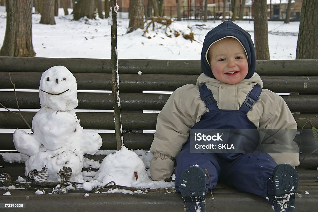 Niña jugando con su muñeco de nieve - Foto de stock de Muñeco de nieve libre de derechos