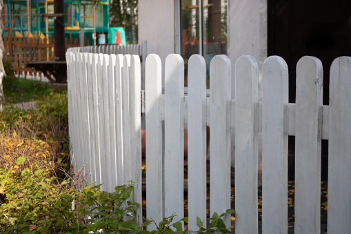 White wooden fence in a children's park on a clear sunny day