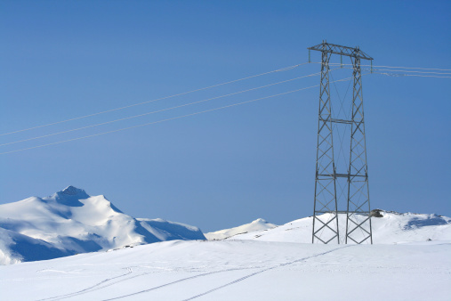 A power line mast in a winter landscape in Norway.