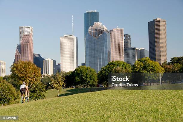 Bicycling Through A City Park Skyline In Background Stock Photo - Download Image Now