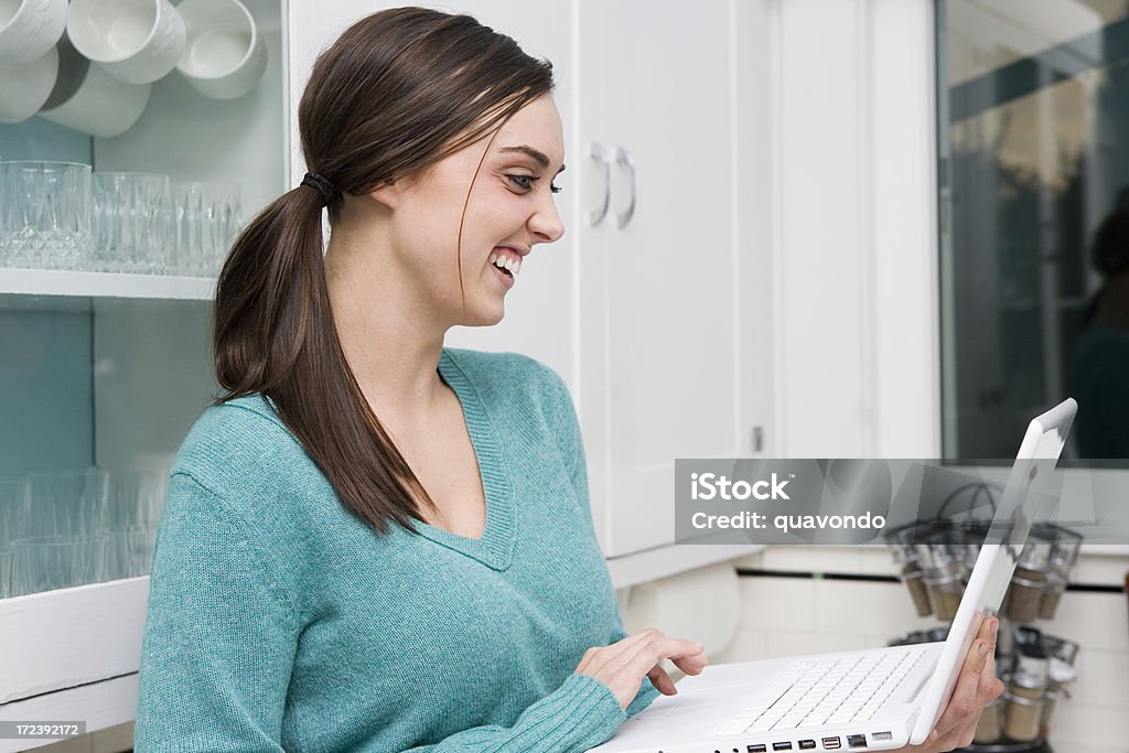 Brunette Jovem mulher rir durante o computador portátil em casa, Copyspace - Royalty-free 20-24 Anos Foto de stock