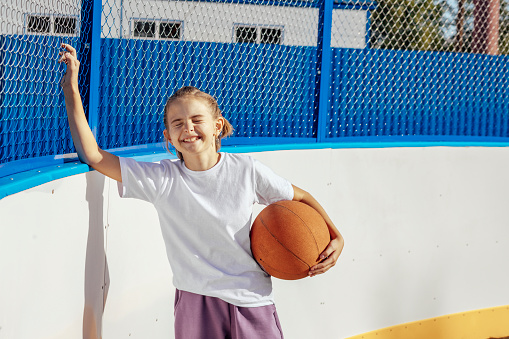 Courage in the Twilight: Girl's Resilience Radiates in Outdoor Basketball Match