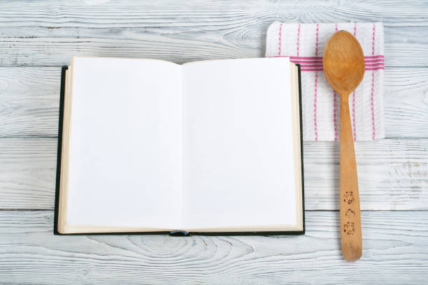 istock Recipe cook blank book on wooden background, spoon, rolling pin, checkered tablecloth. Top view 1723925085